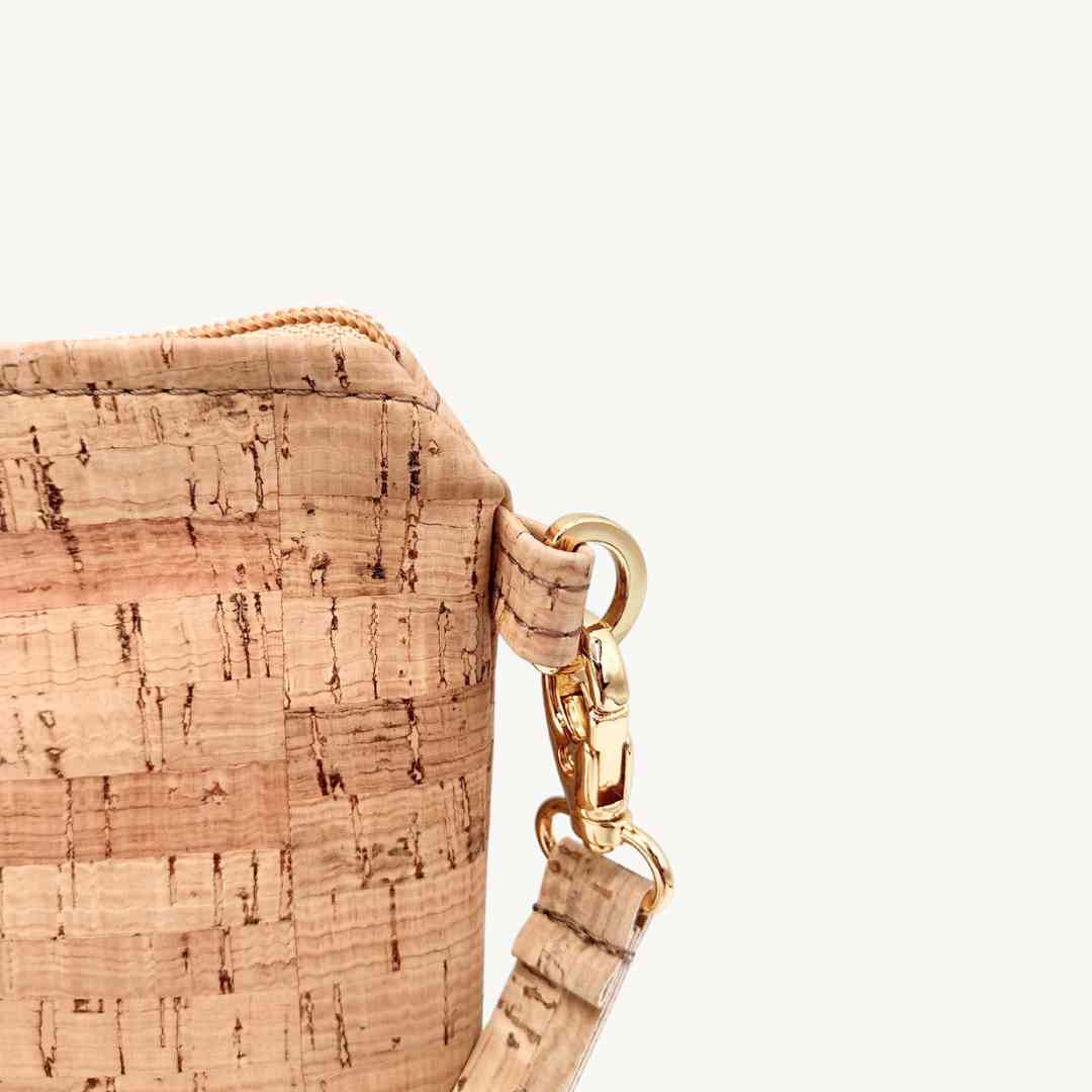 Close-up of the vegan cork leather wristlet's textured surface and subtle stitching detail at the corner.