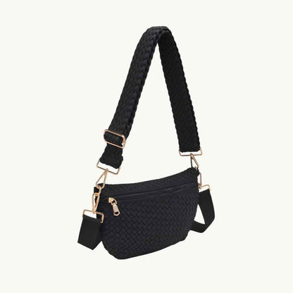 Black vegan woven crossbody bag with a braided shoulder strap and gold-tone hardware, shown on a plain off-white background.