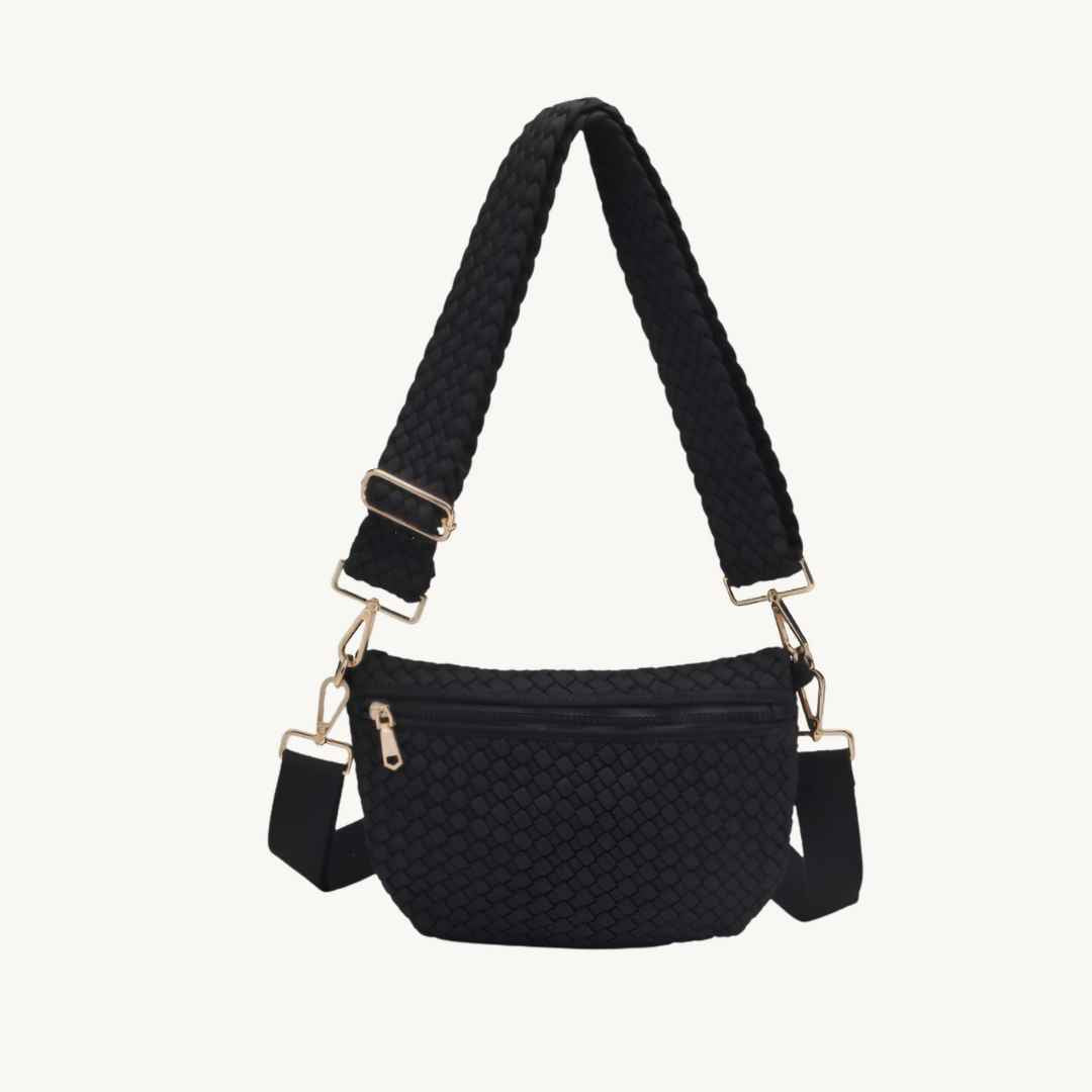 Black woven crossbody bag that is vegan with a braided shoulder strap and gold-tone hardware, shown against a plain off-white background.