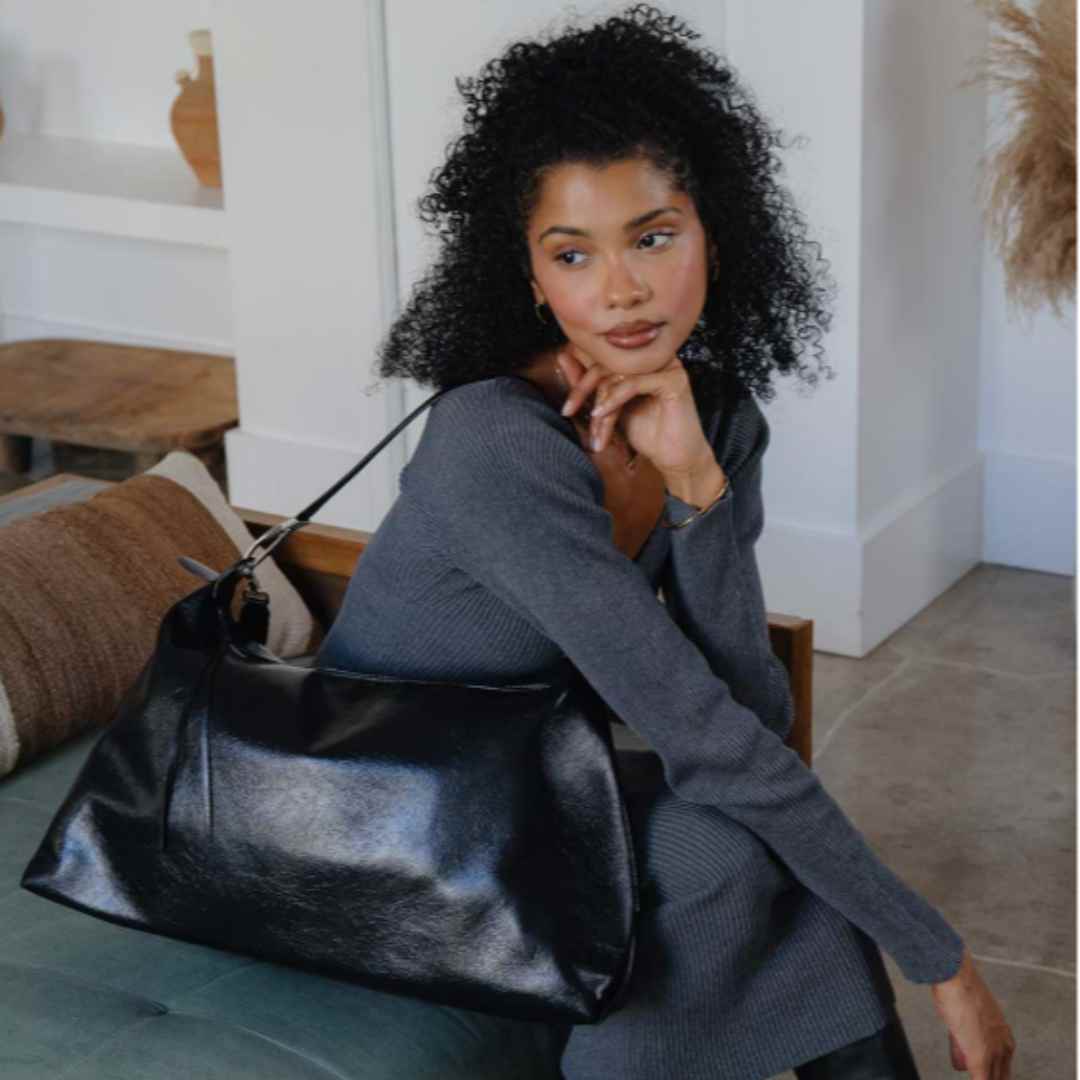 Close-up of the Charlie vegan tote bag’s recycled leather texture and subtle embossed logo label on the front panel.