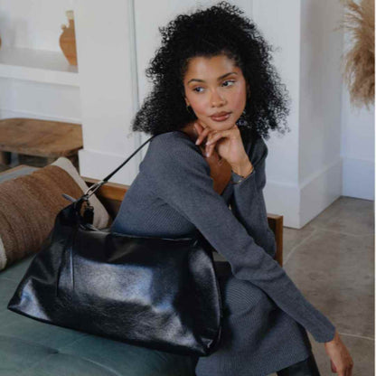 Close-up of the Charlie vegan tote bag’s recycled leather texture and subtle embossed logo label on the front panel.
