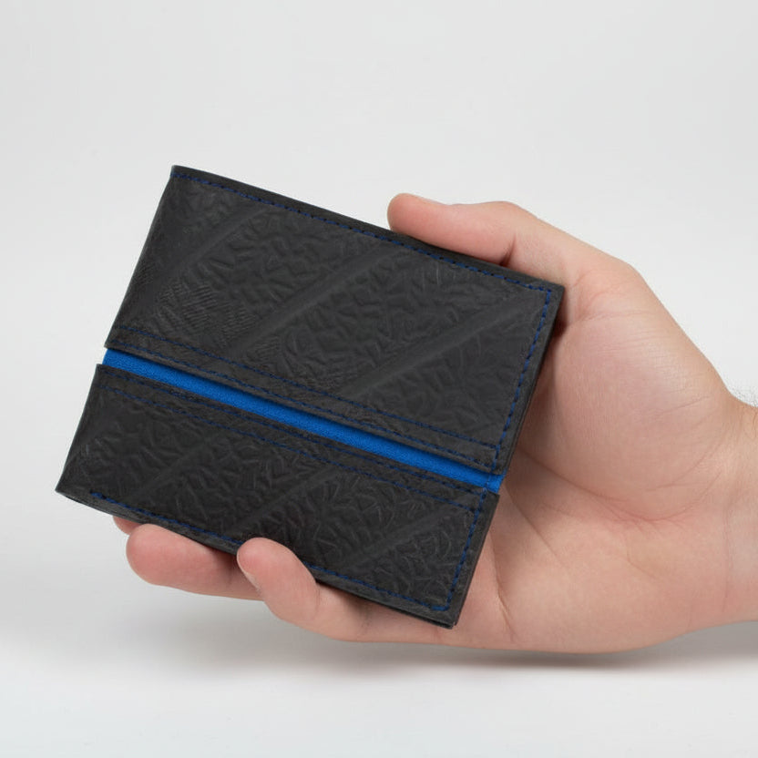 Close-up of the Georgie wallet’s upcycled cork fabric texture and embossed vegan logo detail from a slightly angled