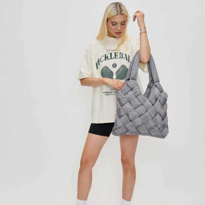 Gray woven vegan leather purse made of recycled nylon being held