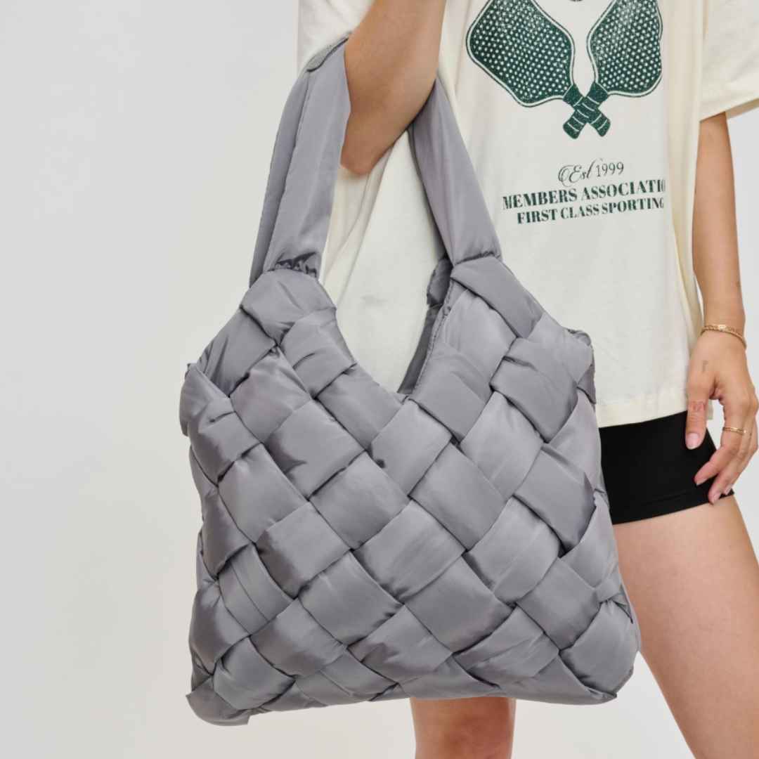 Gray woven vegan leather purse made of recycled nylon being held