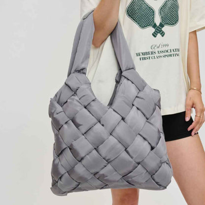 Gray woven vegan leather purse made of recycled nylon being held