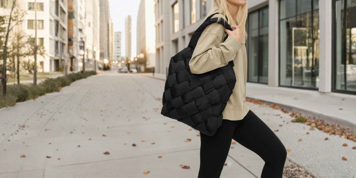 A woman carrying a large black woven quilted vegan leather bag.