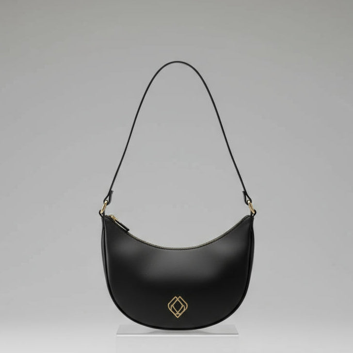Black leather handbag with a gold buckle on a white background