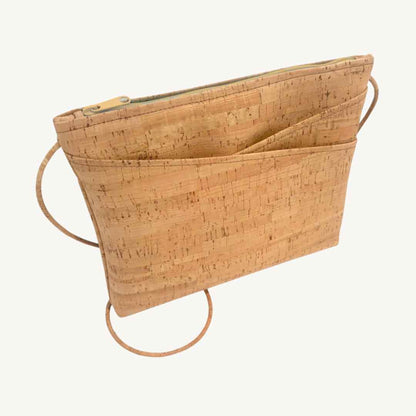 Close-up of the cork vegan crossbody strap featuring brass metal hardware and adjustable chain, showcasing texture and