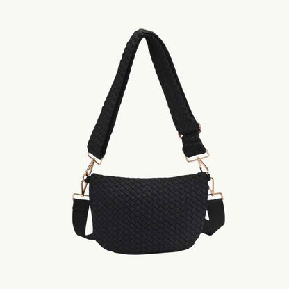 A black woven vegan crossbody bag with a wide braided shoulder strap and gold-tone hardware