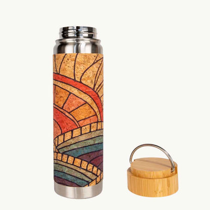Close-up of textured bamboo cap with cork band and engraved logo on the water bottle's translucent body