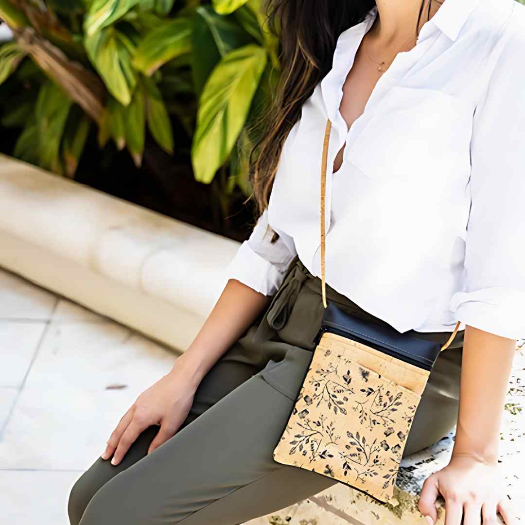 Close-up of textured tan canvas fabric displaying subtle woven pattern and leather-trimmed adjustable strap detail.