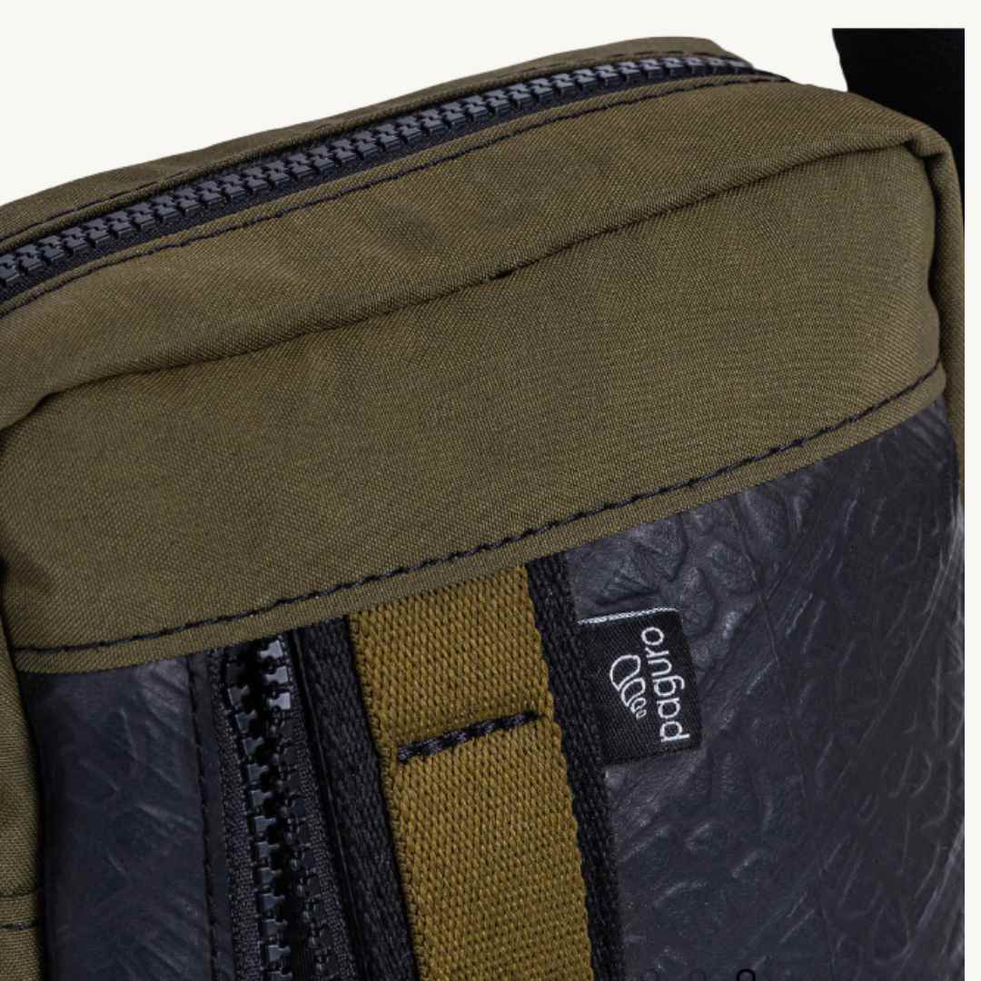 Close-up of the bag’s braided leather strap attachment and rugged Military Canvas corner detailing.