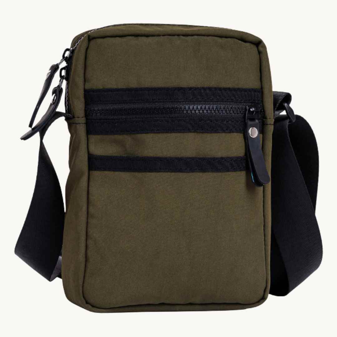 Close-up of the bag's durable military canvas strap attachment and rugged rubber detailing at the corner.