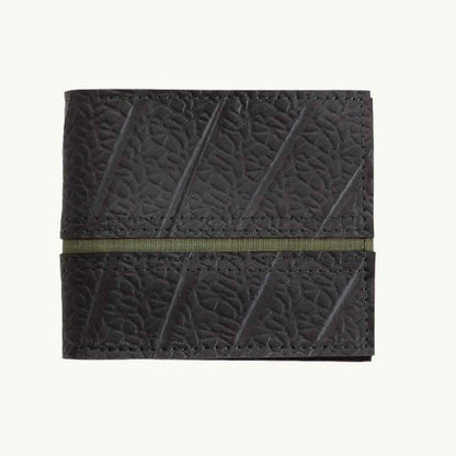 Close-up of the vegan crossbody bag's textured cork material and adjustable strap buckle detail from an angled top view.